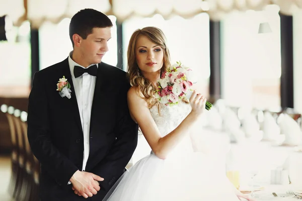 Recém-casados posar em um salão de restaurante de luxo — Fotografia de Stock