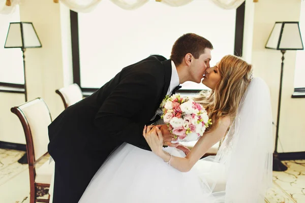Noivo dobra noiva em pé no meio de h do restaurante — Fotografia de Stock