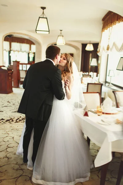 Şefkatle bir lüks salonunda duran bir gelin damat kisses 