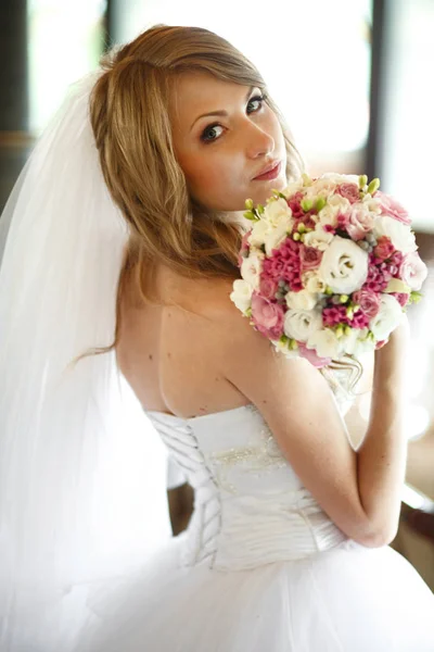 Menyasszony úgy néz ki, a vállára, s kezében egy esküvői cso — Stock Fotó
