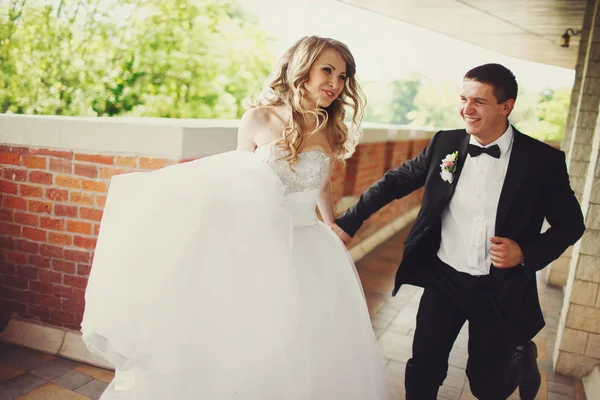 Groom corre segurando a mão da noiva — Fotografia de Stock