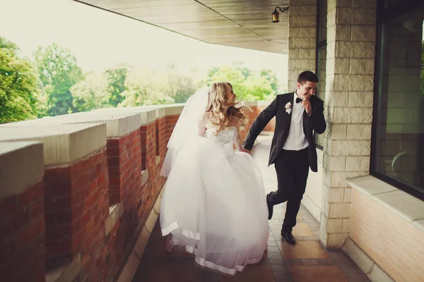 Groom se diverte andando com a noiva ao longo da varanda — Fotografia de Stock