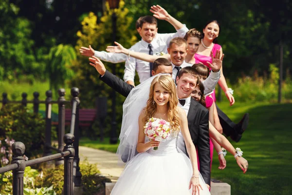 Brautjungfern und Trauzeugen posieren mit offenen Händen, die hinter g stehen — Stockfoto