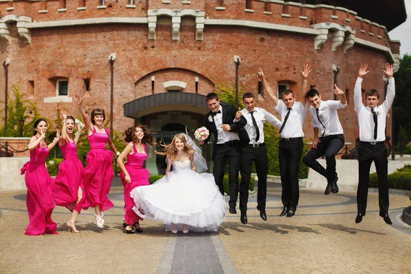 Matrimonio coppia e amici divertirsi saltando nella parte anteriore di un o — Foto Stock