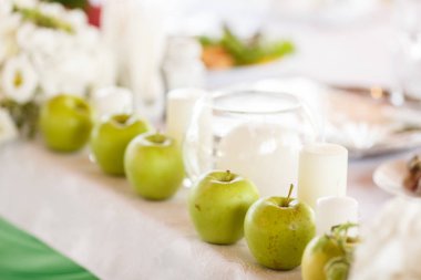 Yeşil elma ve yemek masası Aralık unsuru olarak beyaz mumlar