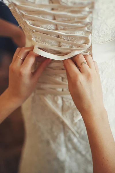 Cordões de dama de honra até um espartilho de um vestido de casamento — Fotografia de Stock