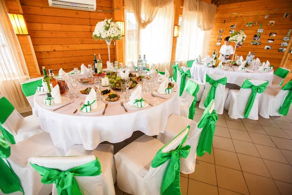 Round tables in restaurants dressed in white and green clothes