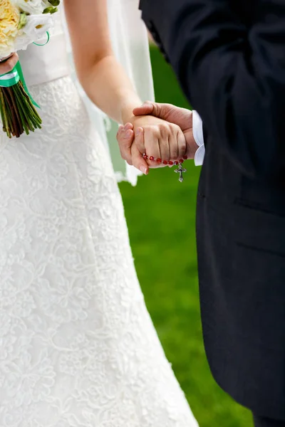 Novia sostiene una cruz en su brazo durante la ceremonia de compromiso — Foto de Stock