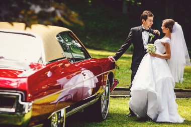 Eski bir Amerikan araba tutarak bir gelin damat eğilir