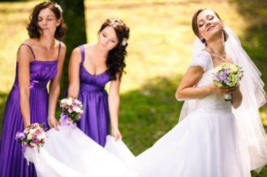 Gelin sahiptir bir güneş nedime elbisesinin tutarken 