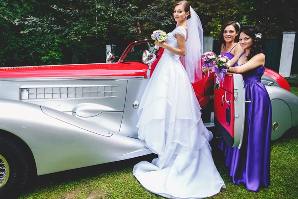 Koszorúslányok ajtót egy vintage autó egy menyasszony — Stock Fotó