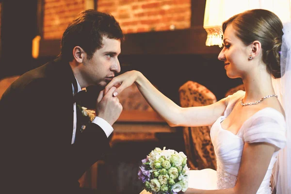 Schöner Bräutigam küsst die zarte Hand der Braut — Stockfoto