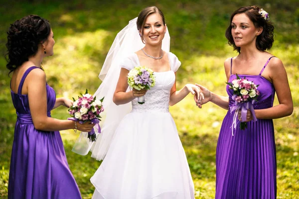 Brautjungfer im violetten Kleid hält beim Reden die Hand der Braut — Stockfoto