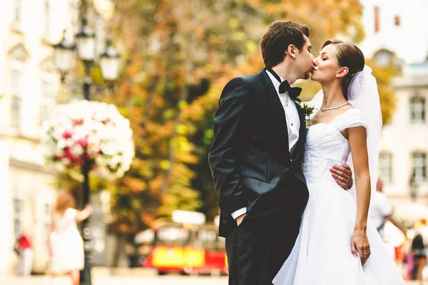 Erstaunliche Hochzeitspaar küsst auf den Straßen der blühenden alten Stadt — Stockfoto