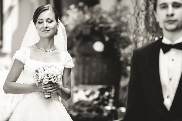 Bride stand with closed eyes in the rays of sun waiting for a gr — Stock Photo, Image