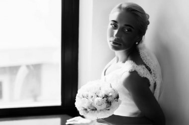 Gelin bir pencere oturan yorgun görünüyor 