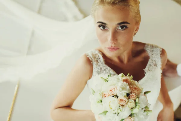 Bruid kijkt recht in de camera leunend op de piano — Stockfoto