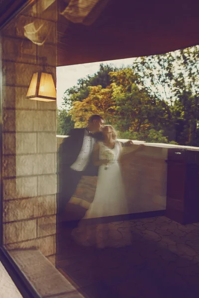 Uma imagem turva de um casal de casamentos em pé na varanda — Fotografia de Stock