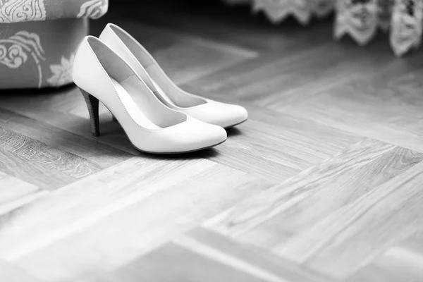 Delicate white shoes stand on the floor — Stock Photo, Image