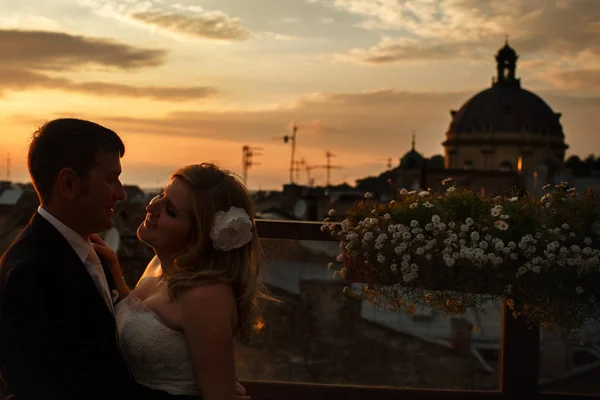 Abendwolken über einem Hochzeitspaar, das auf dem Dach steht — Stockfoto