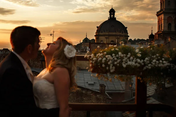 Ein Hochzeitspaar steht auf dem Dach mit toller Architektur — Stockfoto