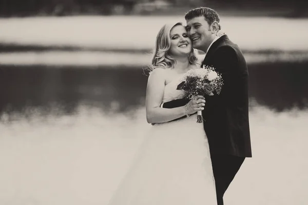 Una imagen en blanco y negro de una feliz pareja de boda de pie beh — Foto de Stock