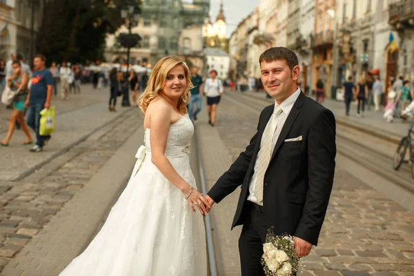 Hochzeitspaar steht irgendwo in der Altstadt in der Straßenbahn — Stockfoto