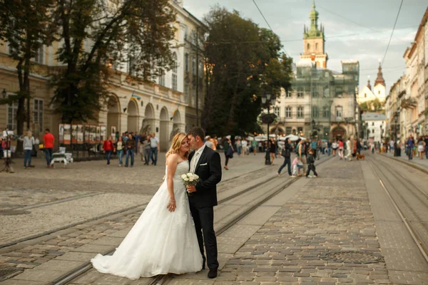 Brudgummen och bruden utmärker trött på gamla gatan upplyst av den — Stockfoto