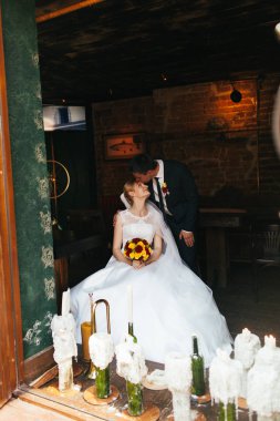 Gelin Damat kisses iken o eski bir restoran bir sandalyede oturur