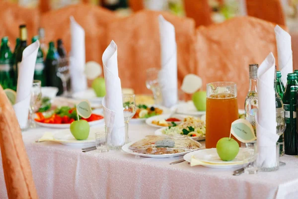 Rijke tafel geserveerd voor een diner en groene appels op een lege plat — Stockfoto