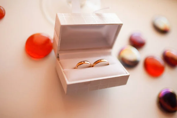 Anéis de casamento em caixa branca jazem em uma mesa cercada por decorati — Fotografia de Stock