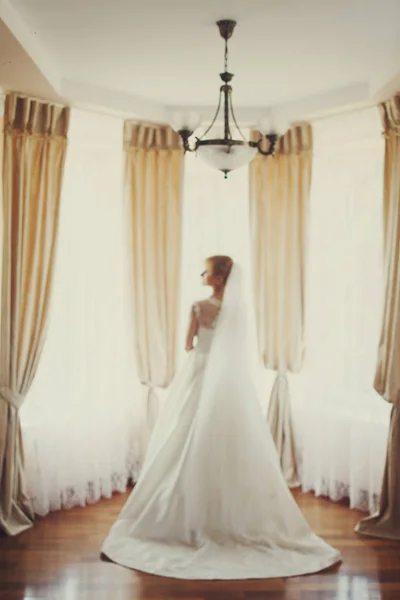 Bride stands in the front of a big window — Stock Photo, Image