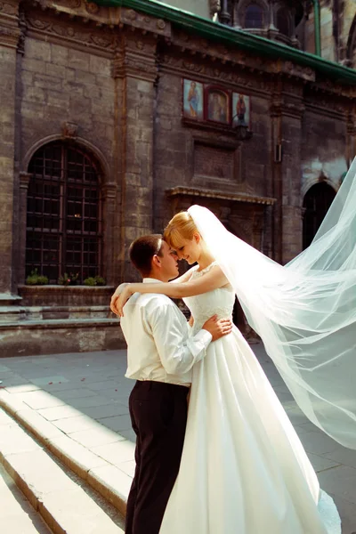 Fiance tient tendrement la taille de la mariée pendant qu'elle se tient debout sur le pas — Photo