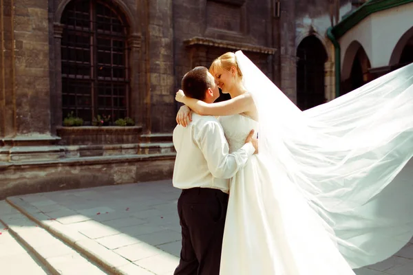 Un couple de mariage baiser dans les lumières du soleil du matin debout behi — Photo