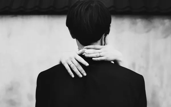 A view from behind on man's back and delicate woman's hands lyin — Stock Photo, Image