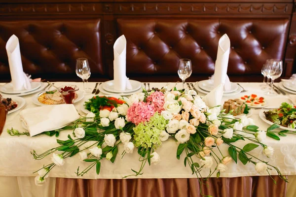 Des bouquets de roses reposent sur la table à manger servie — Photo