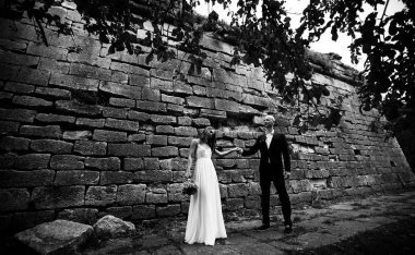 Gelin ve damat bir c eski bir duvarın arkasında muhteşem ayakta bakmak