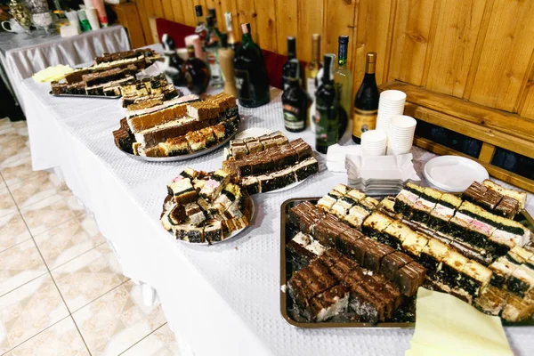 Diferentes tipos de bolos estão cortados em pratos grandes — Fotografia de Stock