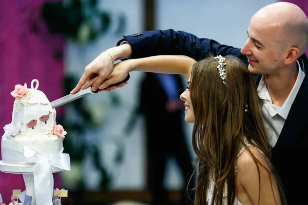 Glückliches Hochzeitspaar schneidet beim ersten Mal Kuchen an — Stockfoto