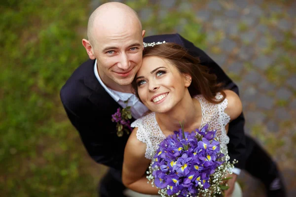Blauäugige Braut und Bräutigam blicken lächelnd in den Himmel — Stockfoto