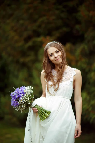 Sorrisi da sposa con un mazzo di crochi viola — Foto Stock