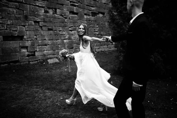 A black and white picture of a stunning bride walking along the — Stock Photo, Image