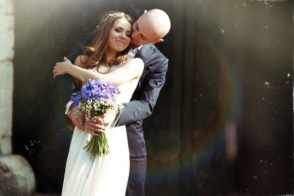 Noivo beija bochecha da noiva abraçando-a por trás nos raios o — Fotografia de Stock