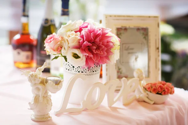 Decoração suave de uma mesa com letras 'love', pink and white fl — Fotografia de Stock