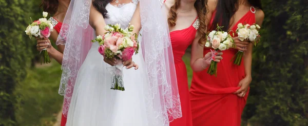 Un primer plano de la novia y las damas de honor en vestidos de color rosa sosteniendo litt —  Fotos de Stock
