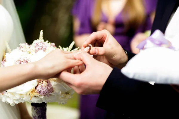 Γαμπρός βάζει ένα γαμήλιο δαχτυλίδι στο δάχτυλό της νύφης λεπτή — Φωτογραφία Αρχείου