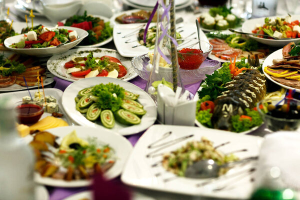 Различные закуски из овощей, рыбы и мяса лежат на белом p
