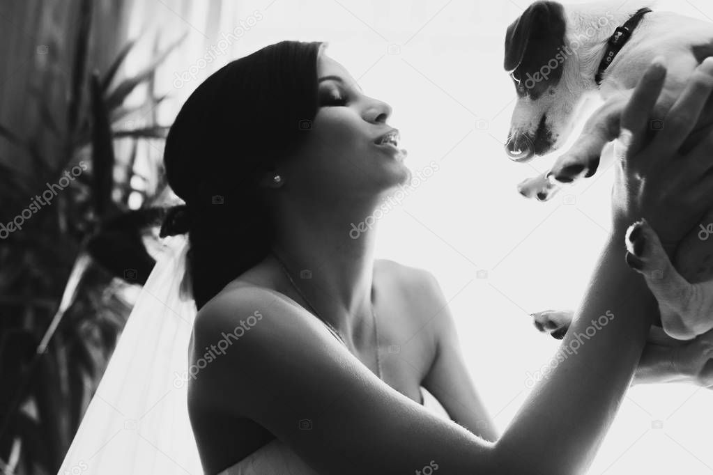 A black and white picture of bride playing with a dog
