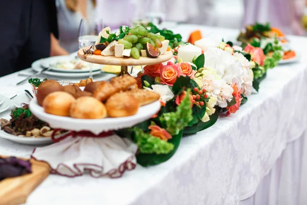 Frutas, queijo, pão e outros aperitivos encontram-se entre decoratio — Fotografia de Stock