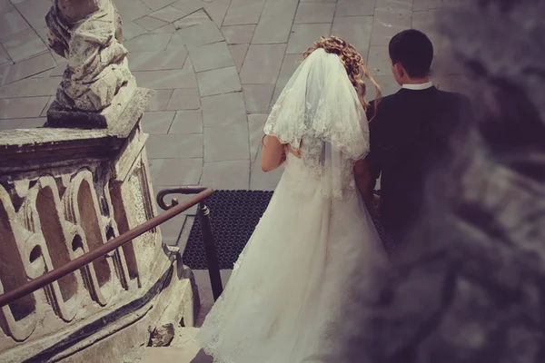 Recém-casados descem velhas escadas de pedra — Fotografia de Stock